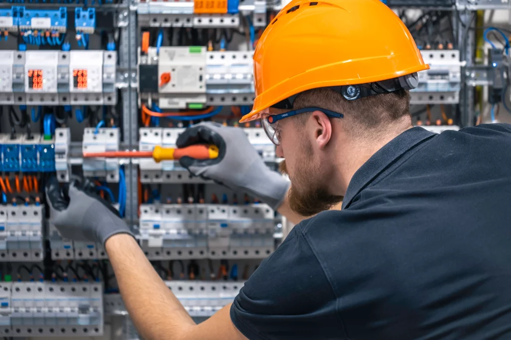 Elektriker arbeitet an Schaltschrank.